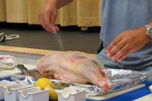 Adding salt and garlic powder to the leg of lamb