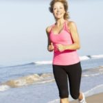 Healthy older woman running at the beach