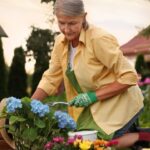 A senior woman working outside in her garden and doing home maintenance